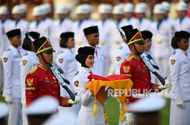 Anggota Paskibraka Ayumi Putri Sasaki (tengah) membawa bendera Merah Putih usai diturunkan dalam Upacara Penurunan Bendera Sang Merah Putih dalam rangka HUT ke-77 Kemerdekaan RI di Jakarta, Rabu (17/8/2022). HUT ke-77 RI tersebut mengangkat tema Pulih Lebih Cepat, Bangkit Lebih Kuat.